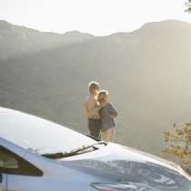 Senior couple looking at mountain view outside car